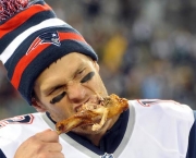 Nov 22, 2012; East Rutherford, NJ, USA; New England Patriots quarterback Tom Brady (12) takes a bite of turkey drumstick after the game against the New York Jets on Thanksgiving at Metlife Stadium. The Patriots won the game 49-19. Mandatory Credit: Joe Camporeale-USA TODAY Sports